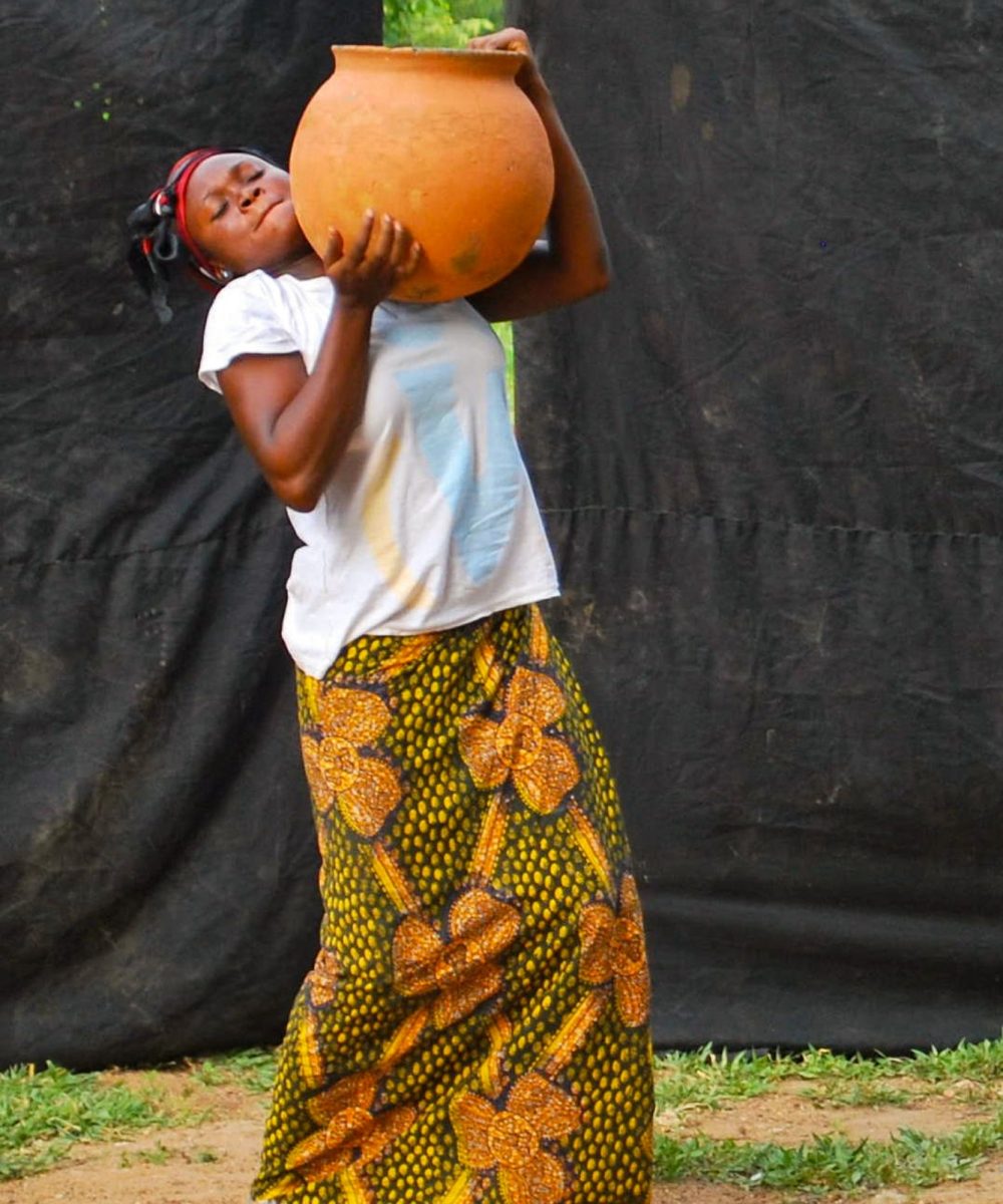 african-lady-wearing-a-big-jug-of-water-wearing-traditional-african-clothes.jpg